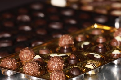 Photo of Many delicious chocolate candies on table, closeup. Production line