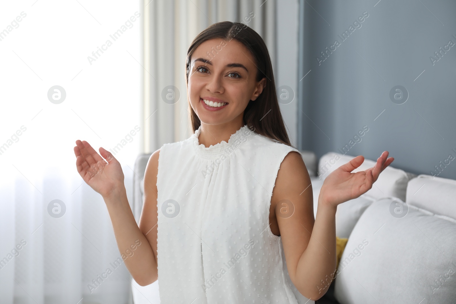 Photo of Young woman talking to his coworkers through video conference indoors, view from webcam