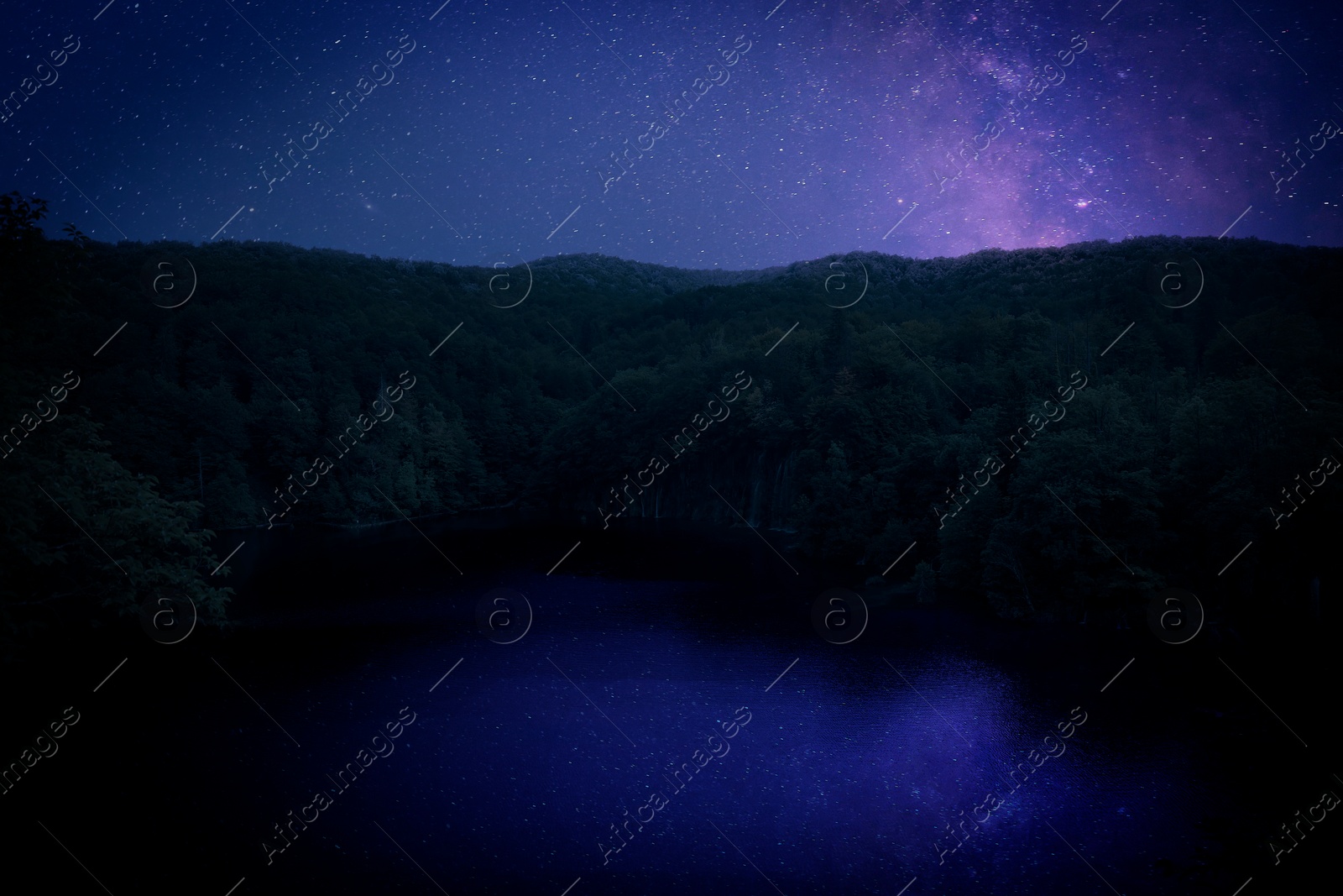 Image of Amazing starry sky reflecting in lake. Beautiful night landscape
