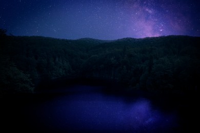 Image of Amazing starry sky reflecting in lake. Beautiful night landscape