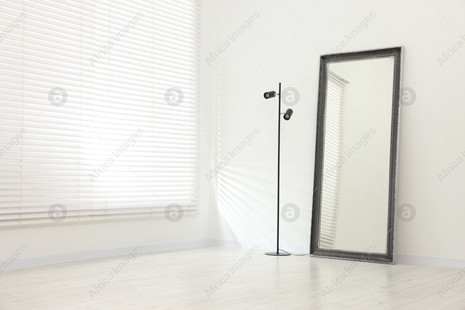 Photo of Stylish makeup room interior with long mirror and lamp. Space for text