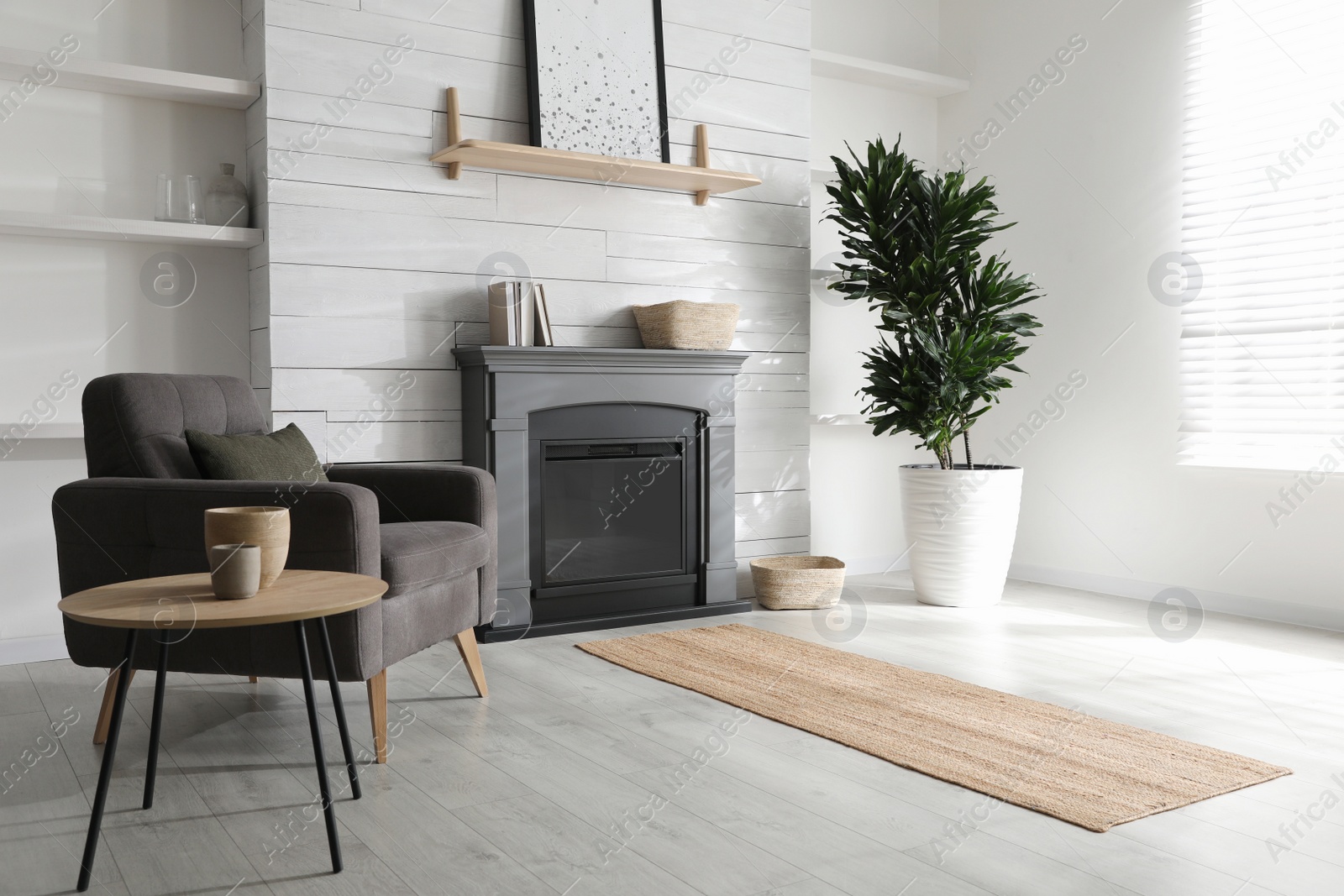 Photo of Cozy living room interior with comfortable armchair and modern electric fireplace