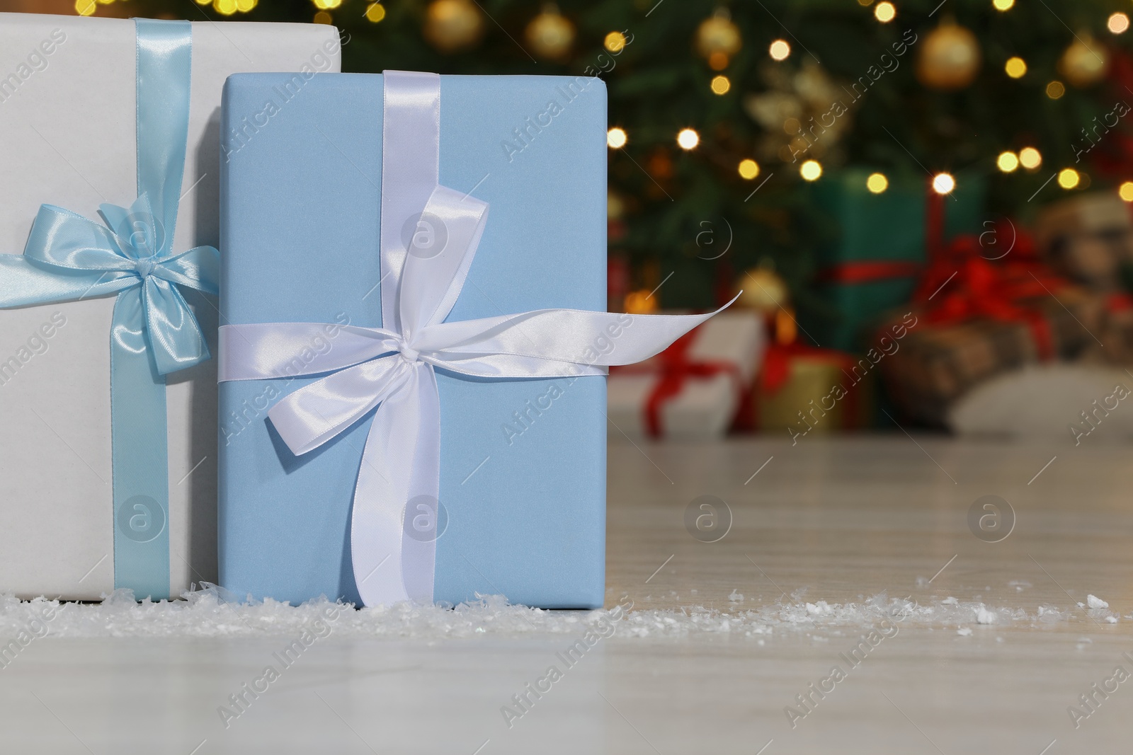 Photo of Gift boxes on floor near Christmas tree in room, space for text