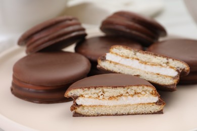 Photo of Heap of delicious choco pies on plate, closeup
