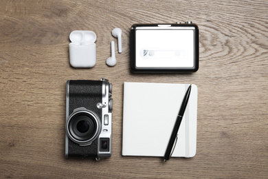 Photo of Flat lay composition with equipment for journalist on wooden table