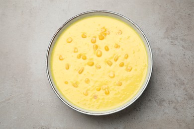 Delicious creamy corn soup on grey table, top view