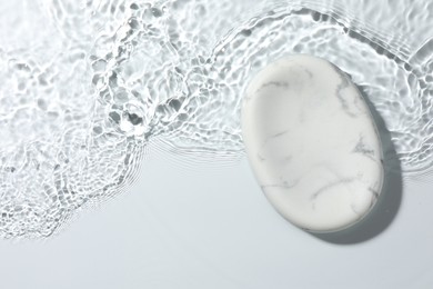 Photo of Presentation of product. Marble podium in water on white background, top view. Space for text