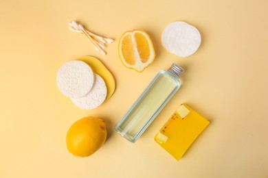 Lemon face cleanser. Fresh citrus fruits and personal care products on beige background, flat lay