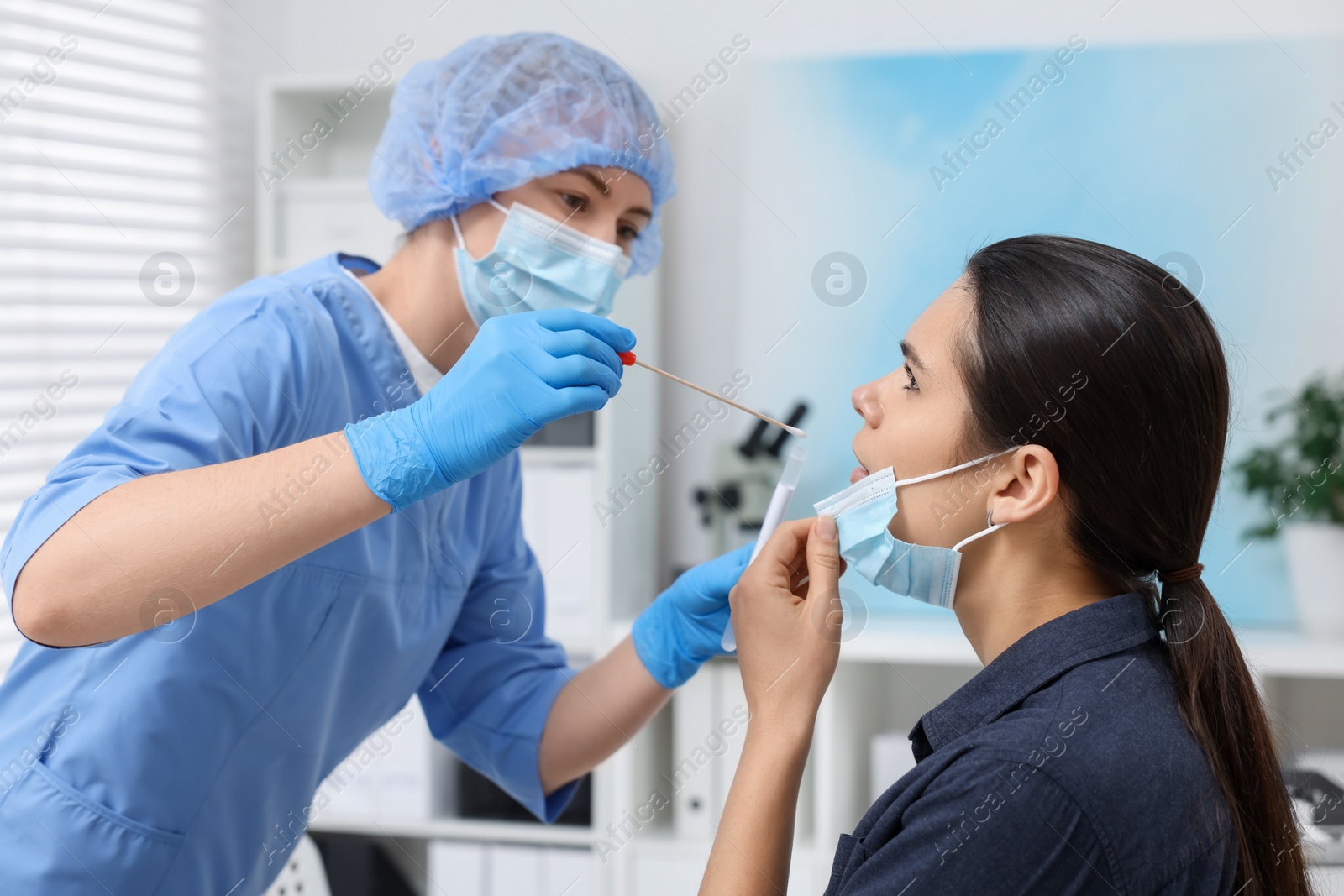 Photo of Laboratory testing. Doctor taking sample from patient's mouth with cotton swab in hospital