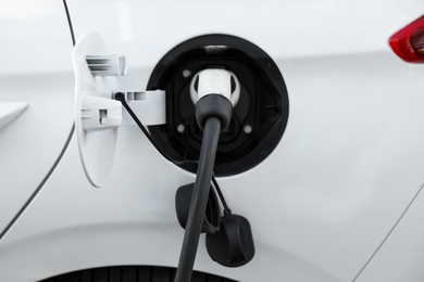 Photo of Charging modern electric car from station, closeup