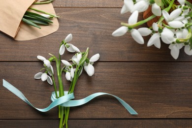 Beautiful snowdrops on wooden table, flat lay