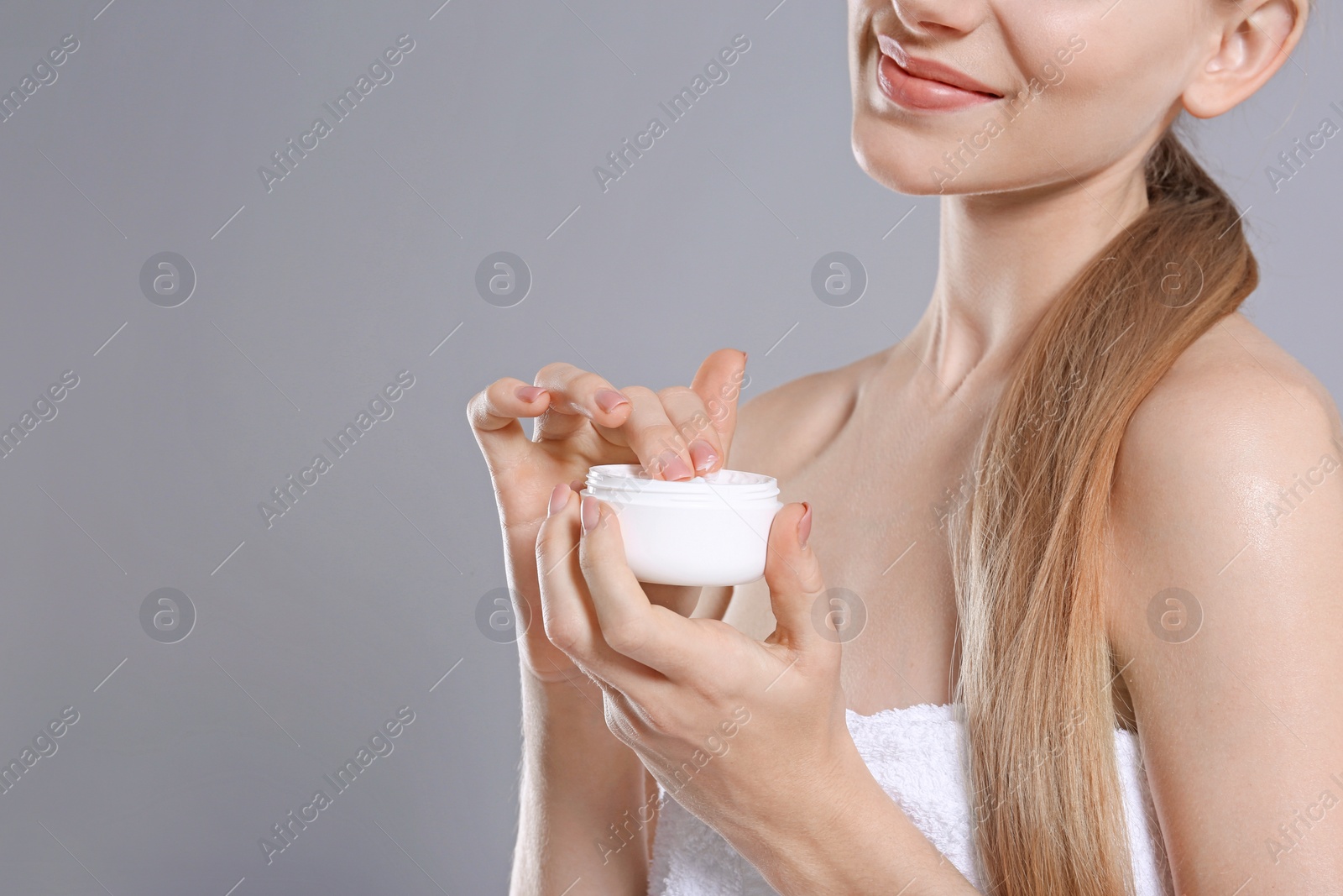 Photo of Young woman with jar of body cream on color background