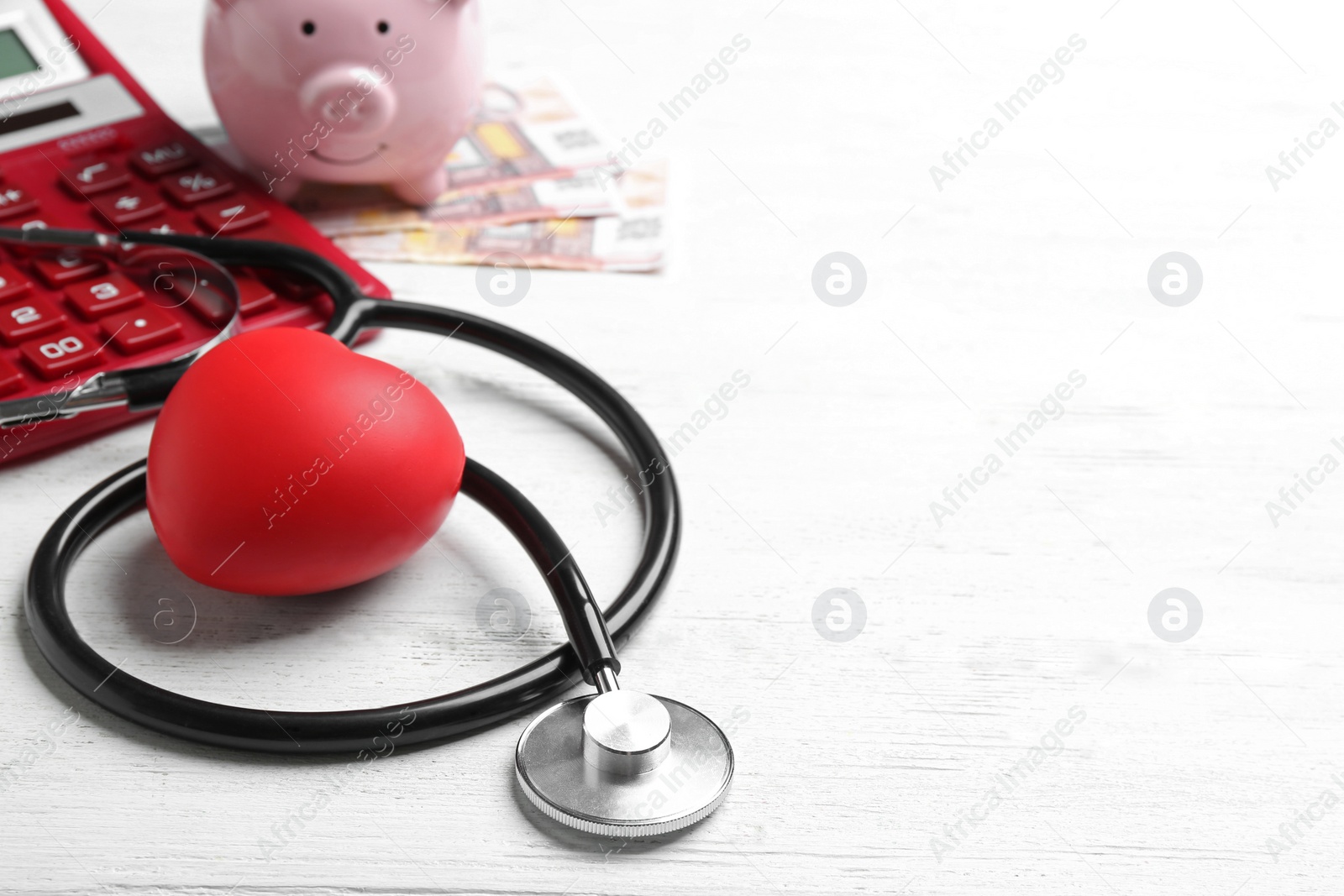 Photo of Stethoscope and red heart on white wooden surface, space for text. Health insurance concept