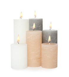 Many alight wax candles on white background