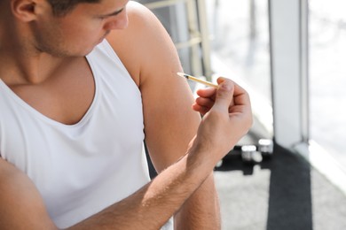 Sportsman injecting himself in gym, closeup. Doping concept