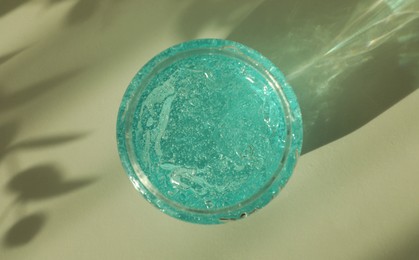 Photo of Jar of blue cosmetic gel on light table, top view