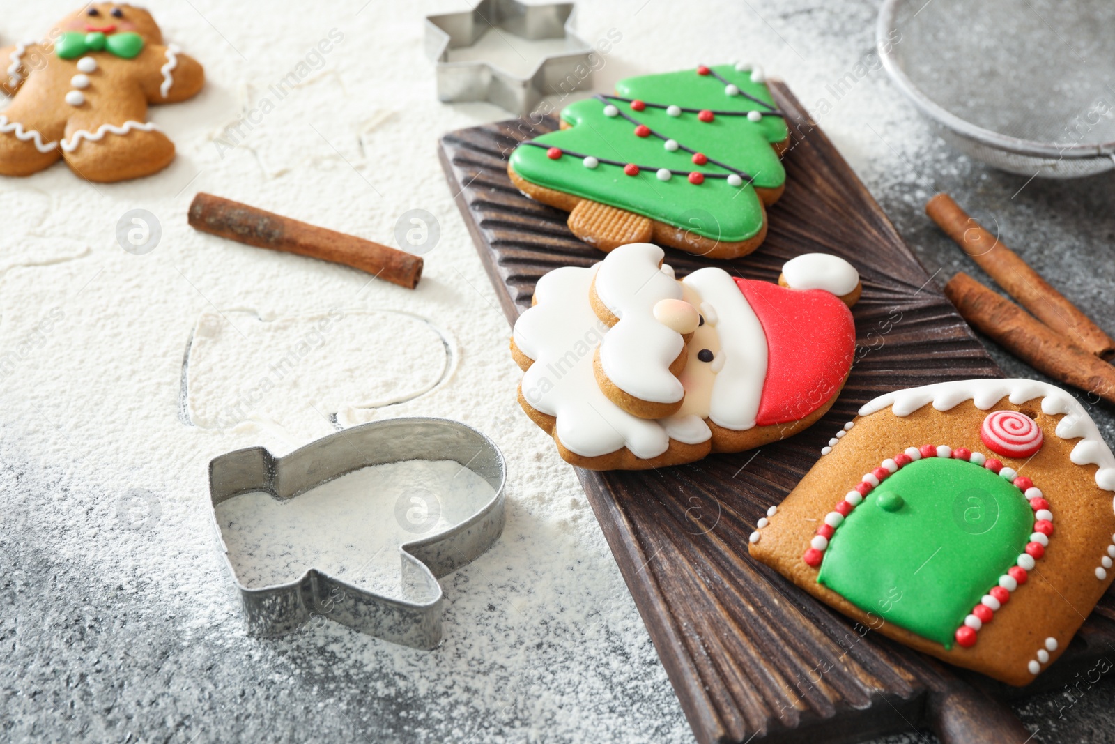 Photo of Delicious homemade Christmas cookies and flour on grey table, closeup