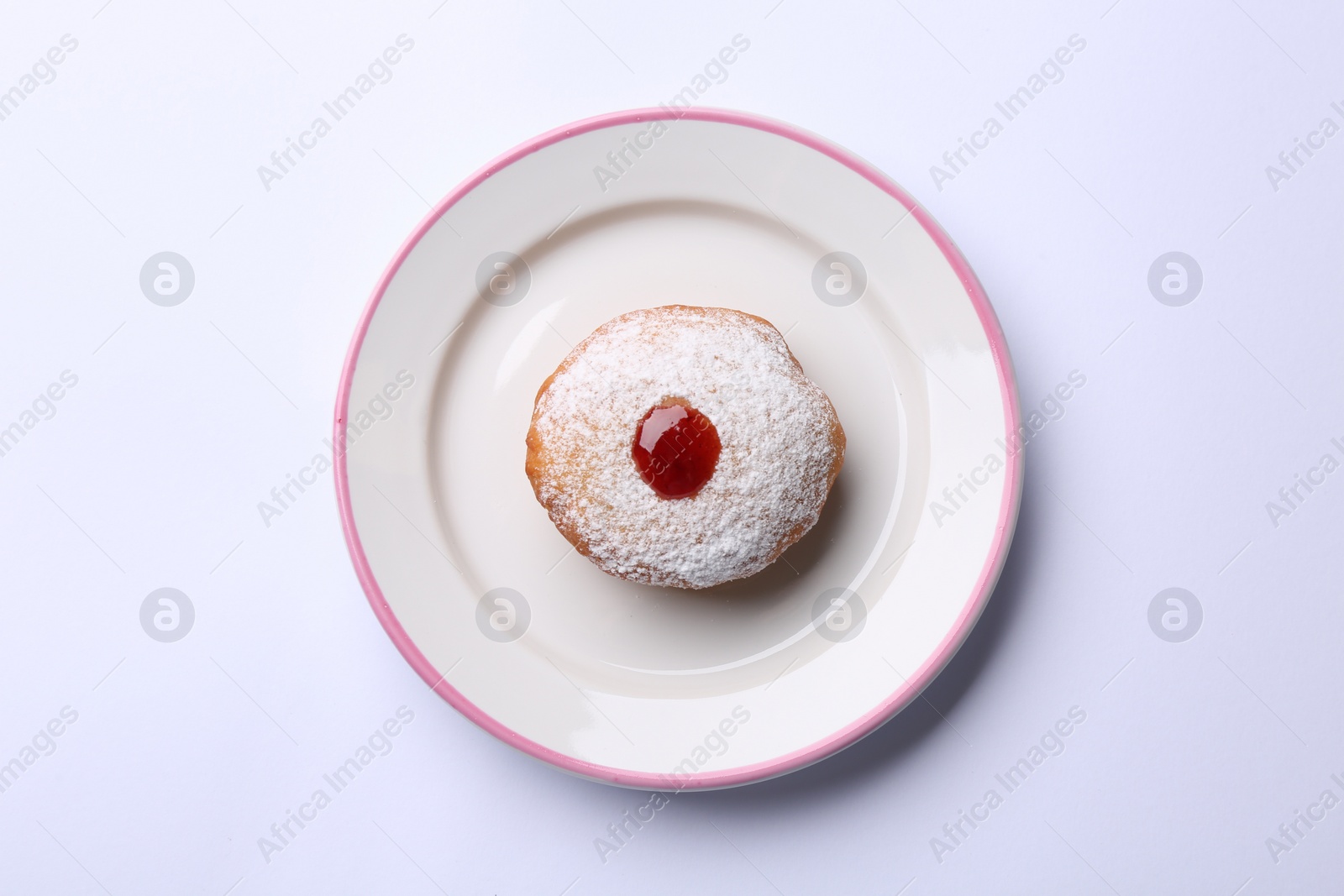 Photo of Hanukkah donut with jelly and powdered sugar on white background, top view