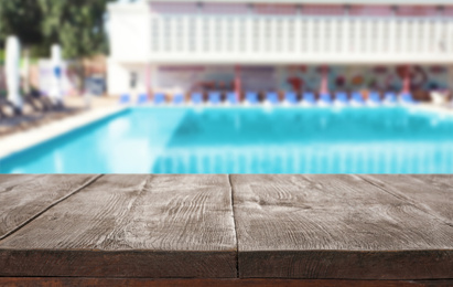 Image of Wooden deck near swimming pool outdoors on sunny day. Space for text