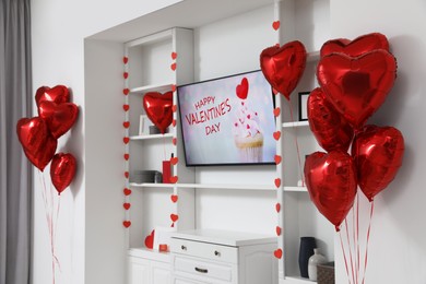 Cozy living room with TV and heart shaped balloons decorated for Valentine Day. Interior design