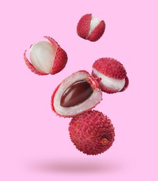 Image of Many fresh lychees falling on pink background