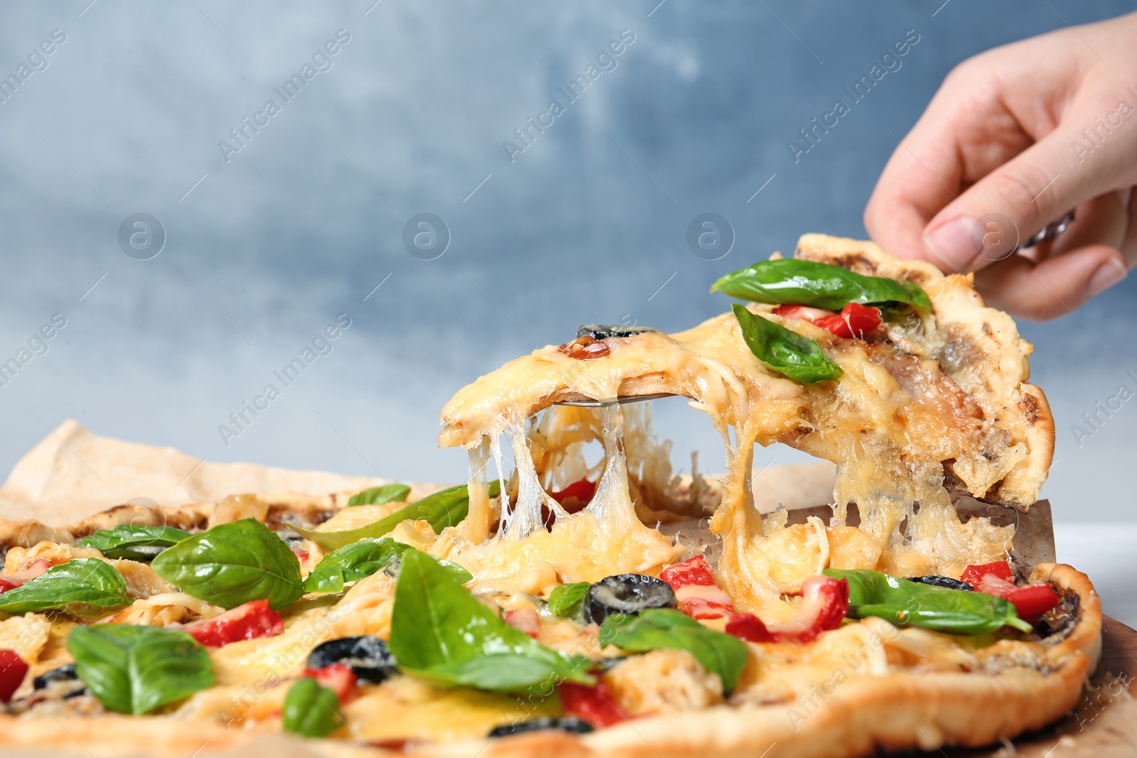 Photo of Woman taking delicious homemade pizza slice with melted cheese, closeup