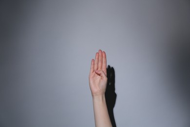 Photo of Woman showing open palm on grey background, closeup