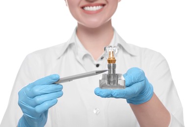 Dentist holding educational model of dental implant on white background, closeup