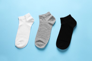 Different socks on light blue background, flat lay