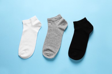 Photo of Different socks on light blue background, flat lay