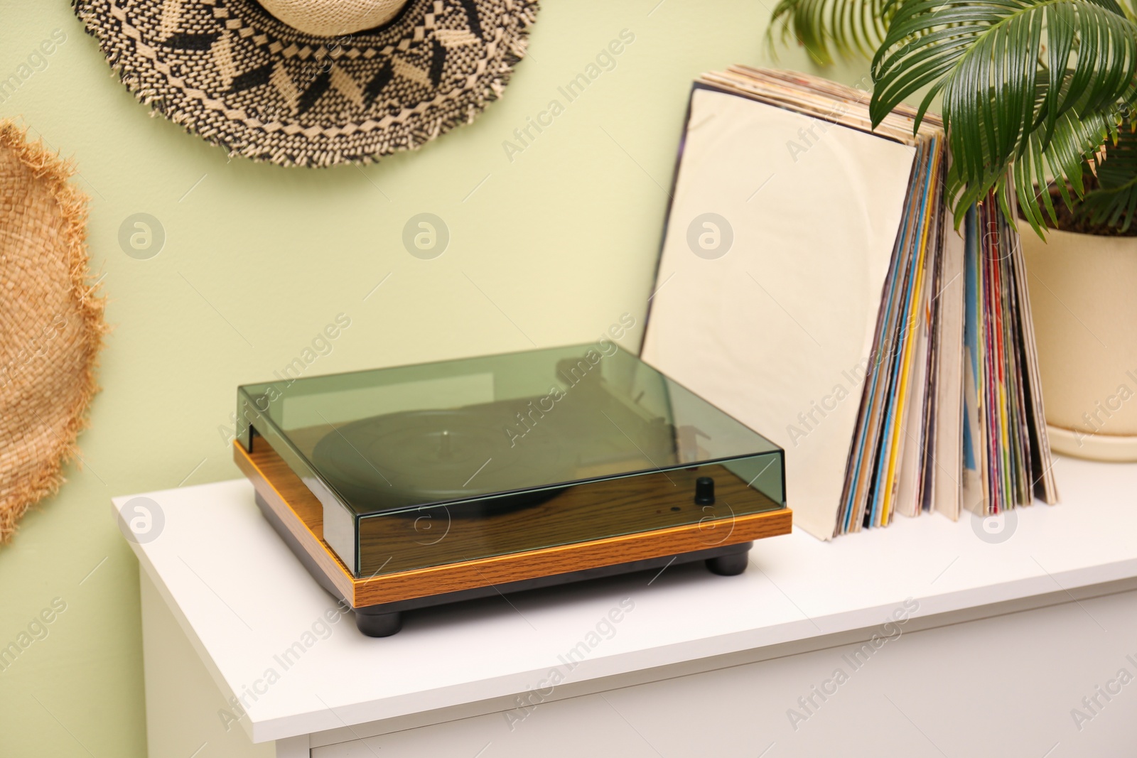 Photo of Turntable and collection of vinyl records on white table indoors