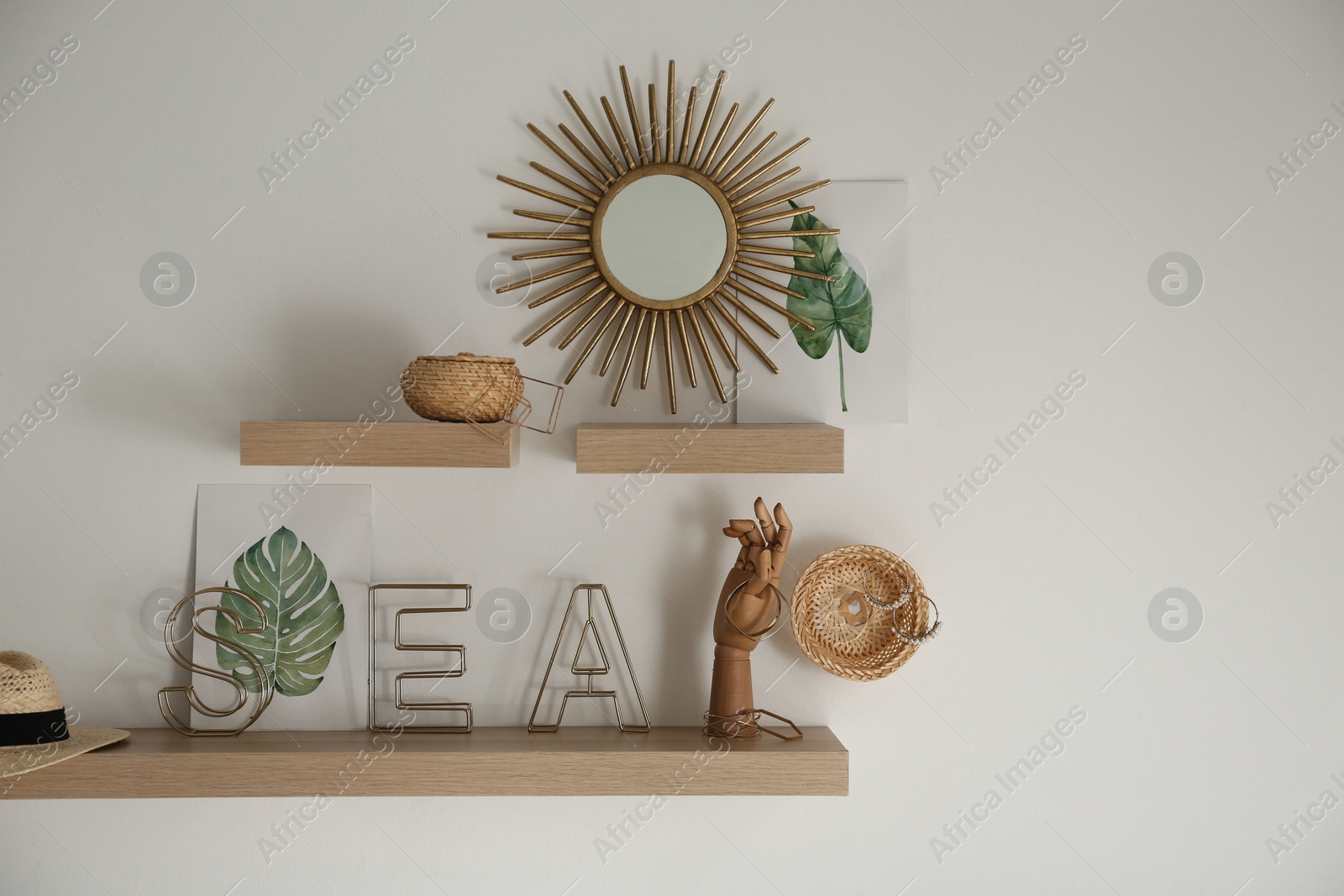 Photo of Wooden shelves with women's accessories and different decorative elements on light wall. Space for text