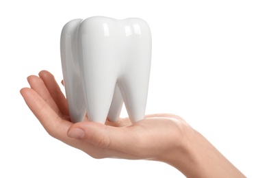 Photo of Woman holding ceramic model of tooth on white background