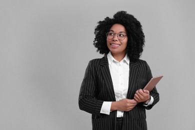 Photo of Young businesswoman with tablet on grey background. Space for text