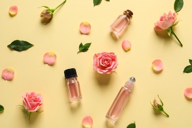 Photo of Flat lay composition with rose essential oil and flowers on color background