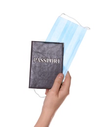 Photo of Woman holding passport and protective mask on white background, closeup. Travel during quarantine