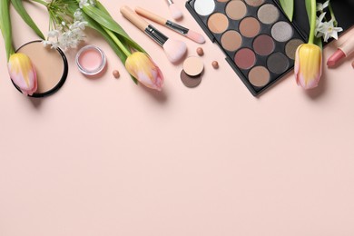 Photo of Flat lay composition with different makeup products and beautiful tulips on beige background, space for text