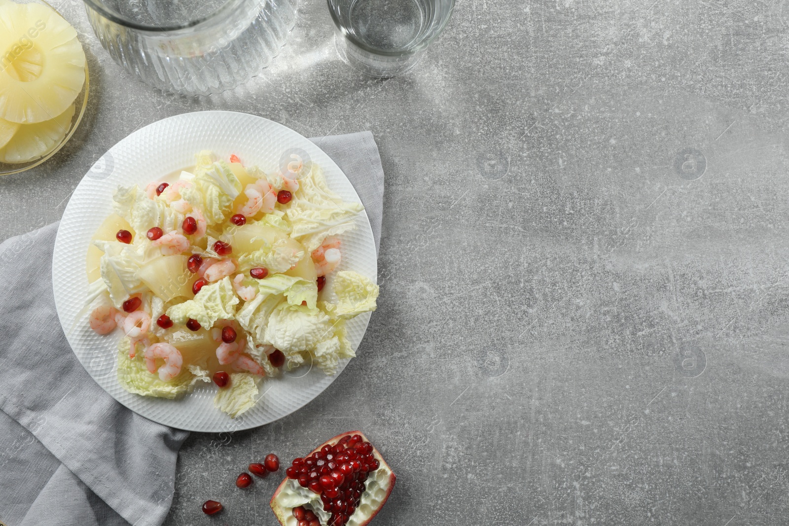 Photo of Delicious salad with Chinese cabbage, shrimps and pineapple served on grey table, flat lay. Space for text