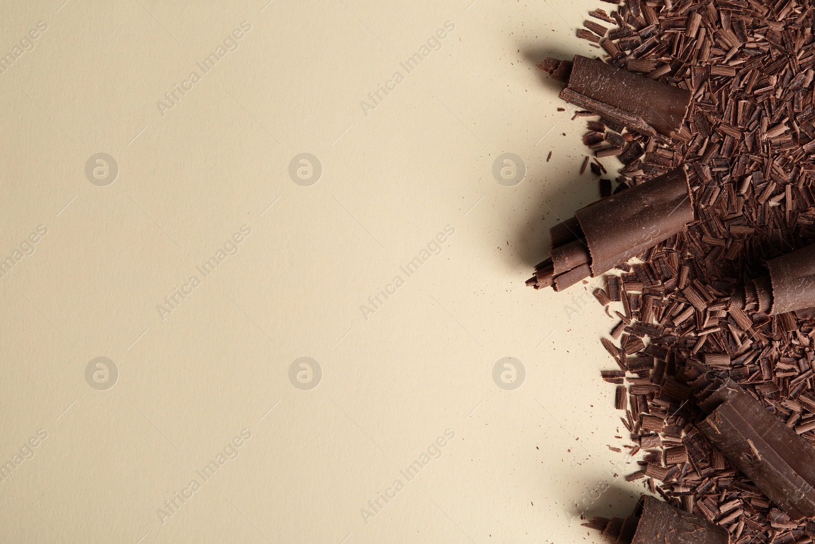 Photo of Chocolate curls and space for text on color background, top view