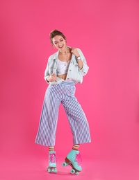 Photo of Young woman with retro roller skates on color background