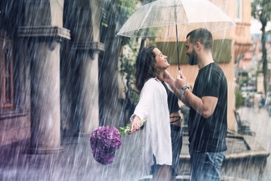 Image of Young couple with umbrella enjoying time together under rain on city street, space for text