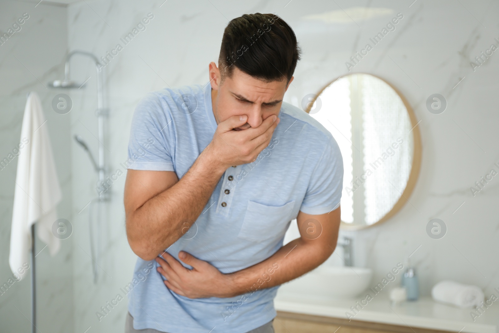 Photo of Man suffering from nausea in bathroom. Food poisoning