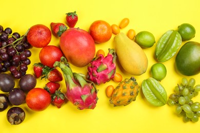 Photo of Assortment of fresh exotic fruits on yellow background, flat lay