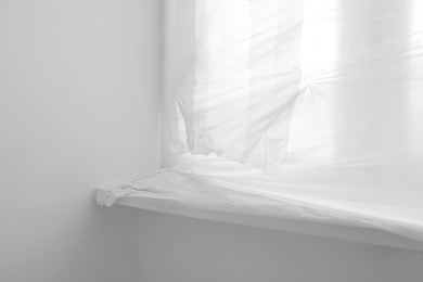 Window and sill covered with plastic film indoors