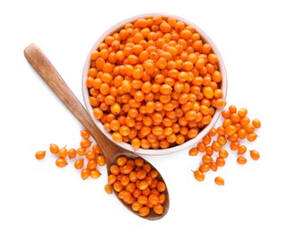 Bowl and wooden spoon with fresh ripe sea buckthorn berries on white background, top view