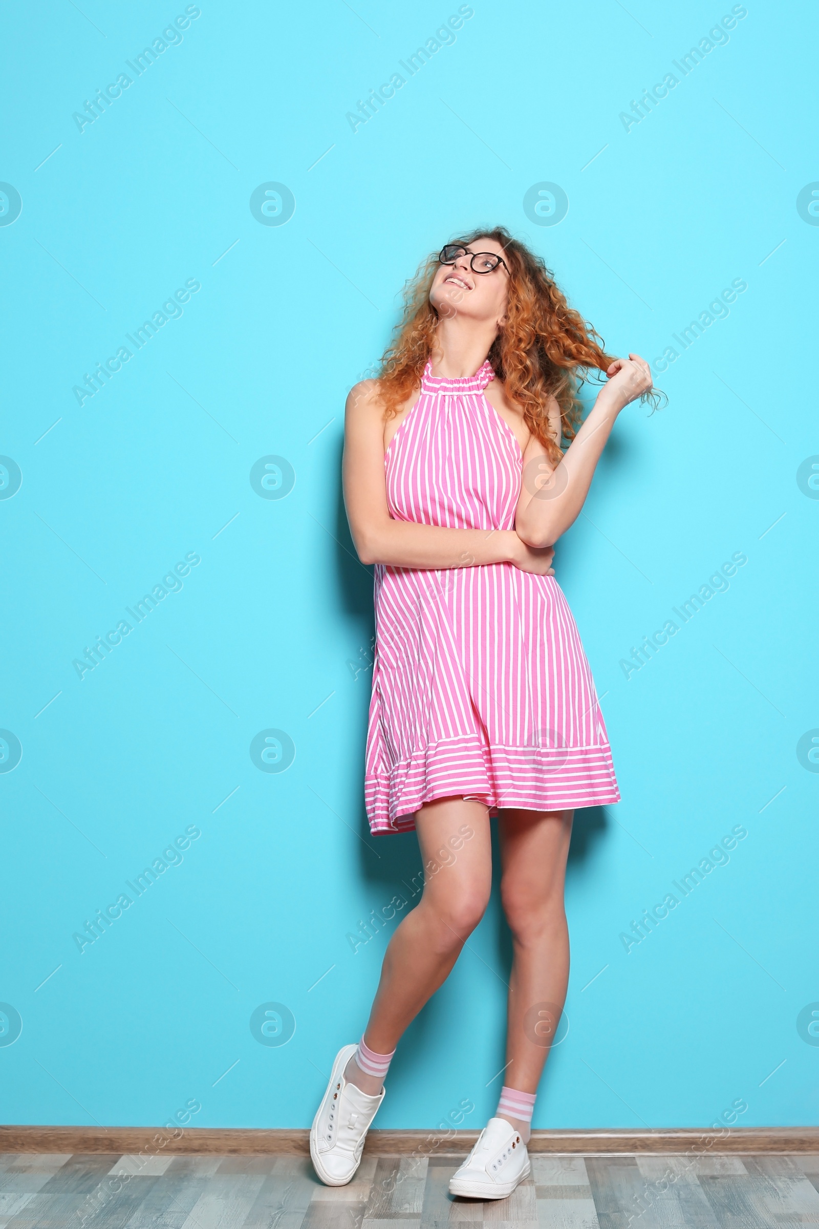 Photo of Full length portrait of beautiful woman with sexy legs near color wall