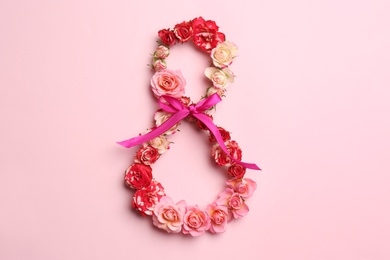 Photo of Number 8 made of beautiful flowers on color background, top view. Happy Women's Day
