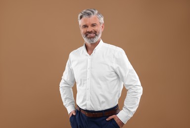 Photo of Portrait of smiling man with beautiful hairstyle on light brown background