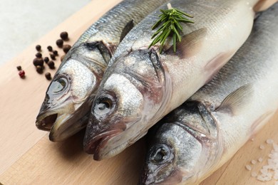 Tasty sea bass fish and spices on grey table, closeup