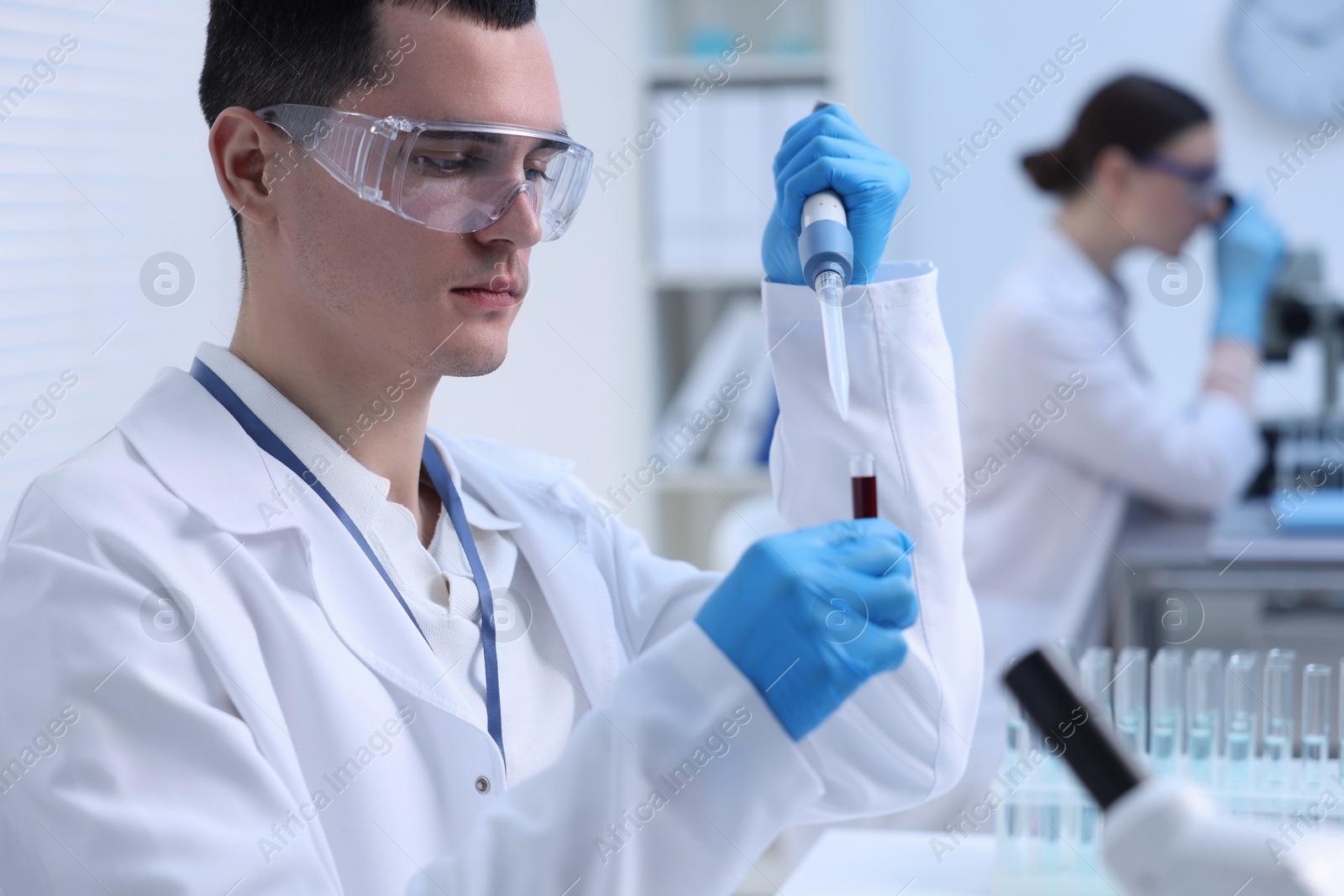 Photo of Scientist dripping sample into test tube in laboratory